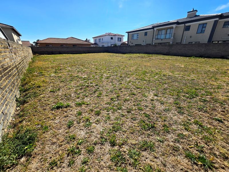 A vacant residential plot enclosed by perimeter boundary walls, offering a clear space ready for development.
