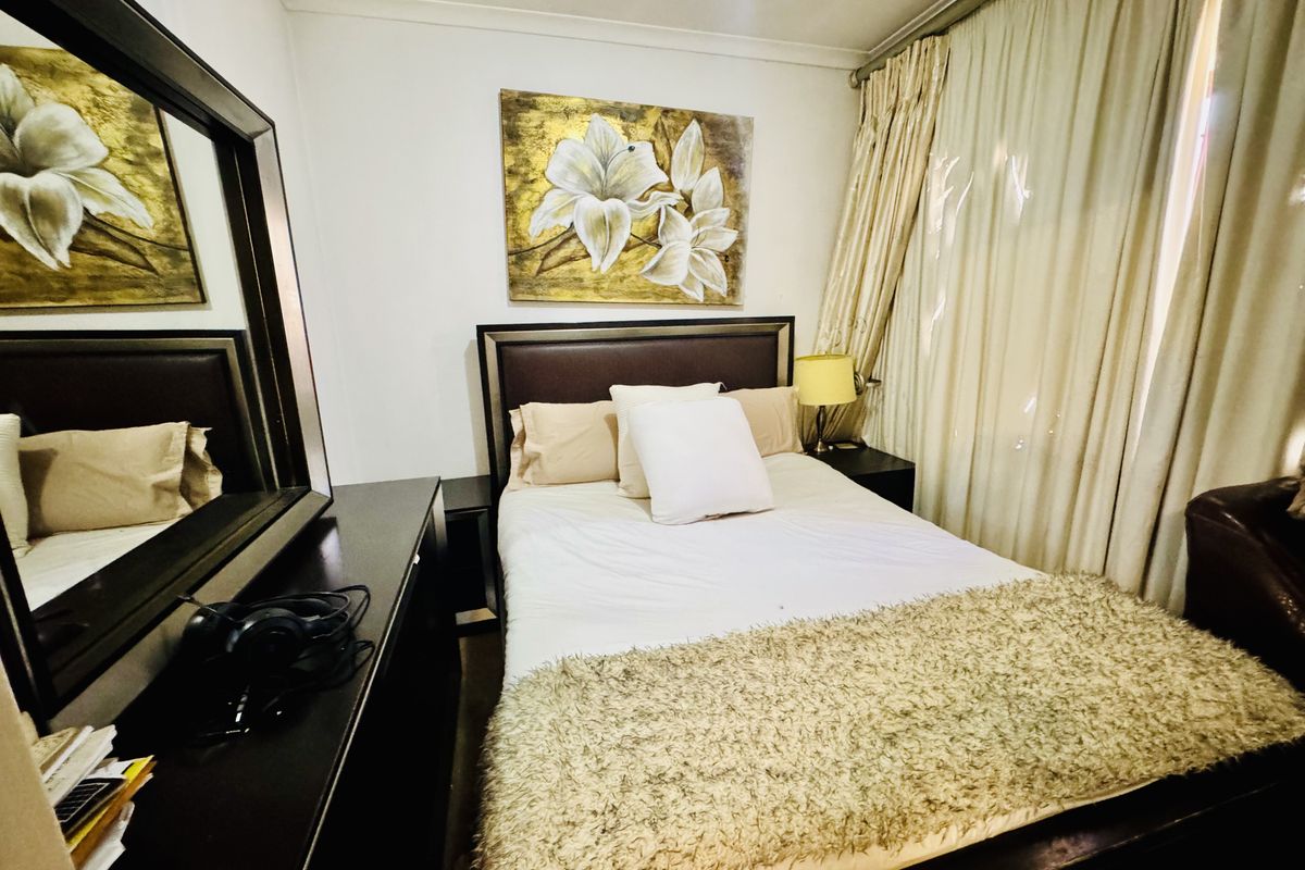 A compact bedroom featuring neutral walls, coving, and floor-to-ceiling curtains.