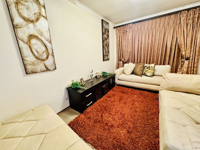 A cozy living room featuring laminate flooring and decorative coving, providing a comfortable space for relaxation.