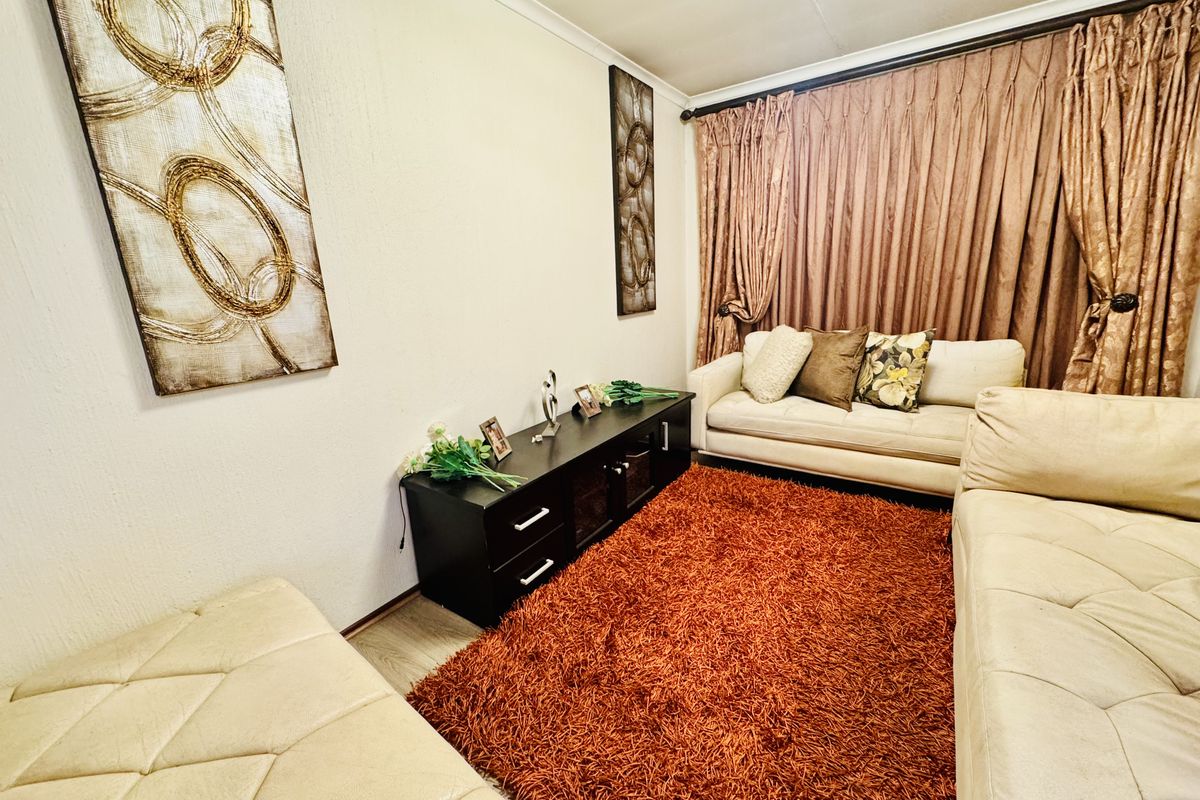 A cozy living room featuring laminate flooring and decorative coving, providing a comfortable space for relaxation.