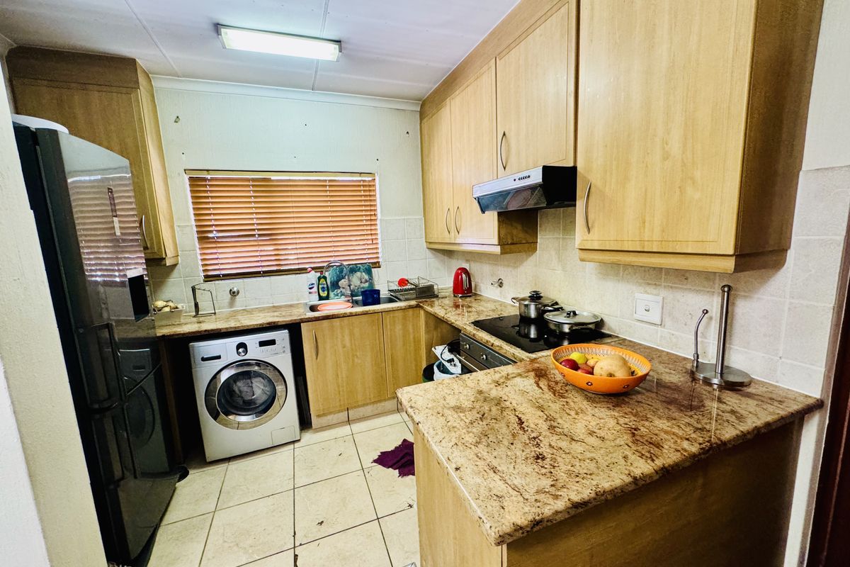 A functional kitchen featuring laminate cabinetry, granite countertops, built-in cooking appliances, and tiled flooring, offering a practical layout for daily meal preparation.