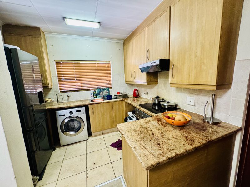 A functional kitchen featuring laminate cabinetry, granite countertops, built-in cooking appliances, and tiled flooring, offering a practical layout for daily meal preparation.