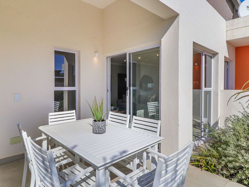 A covered patio area featuring tiled flooring and sliding glass doors providing seamless access to the interior living space.