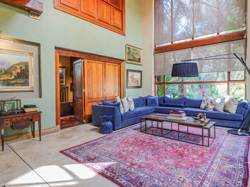 Spacious double-volume living room featuring polished concrete floors, large windows with natural light, and elegant wooden architectural details.