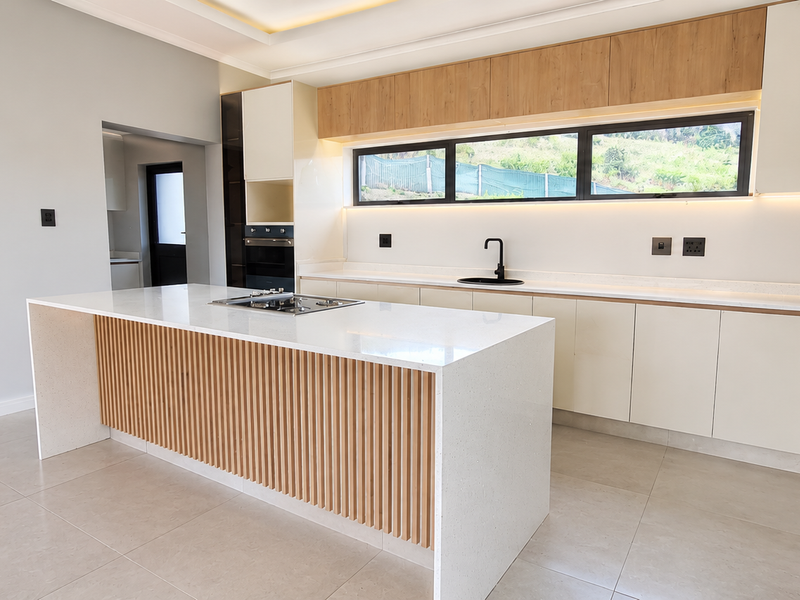 Modern, high-end kitchen featuring a central island with slatted wood detailing, quartz countertops, integrated appliances, and sleek cabinetry with ambient under-cabinet lighting.
