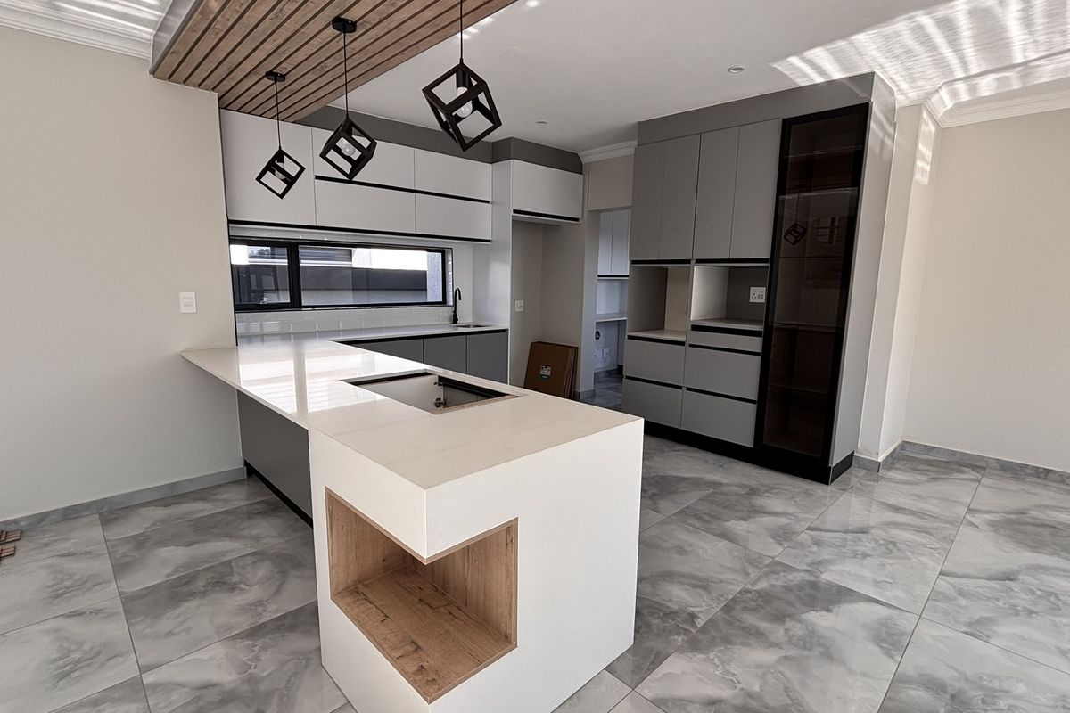 Modern kitchen featuring a central island with quartz countertops, sleek grey cabinetry, timber slat ceiling accents, and high-quality porcelain floor tiles.
