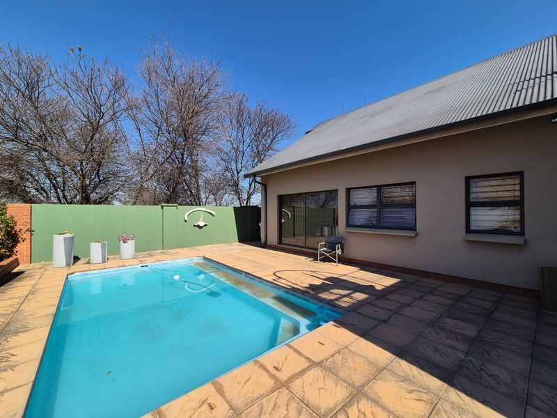 Outdoor pool area featuring a paved patio, swimming pool, and direct access to the home via sliding glass doors.