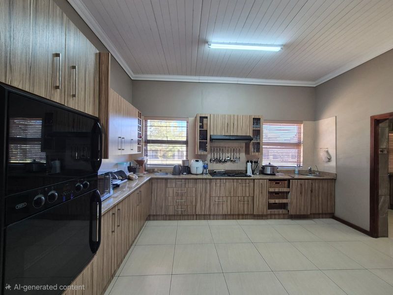 Spacious kitchen featuring wood-grain cabinetry, built-in oven, hob, extractor fan, and tiled flooring with ample counter space.
