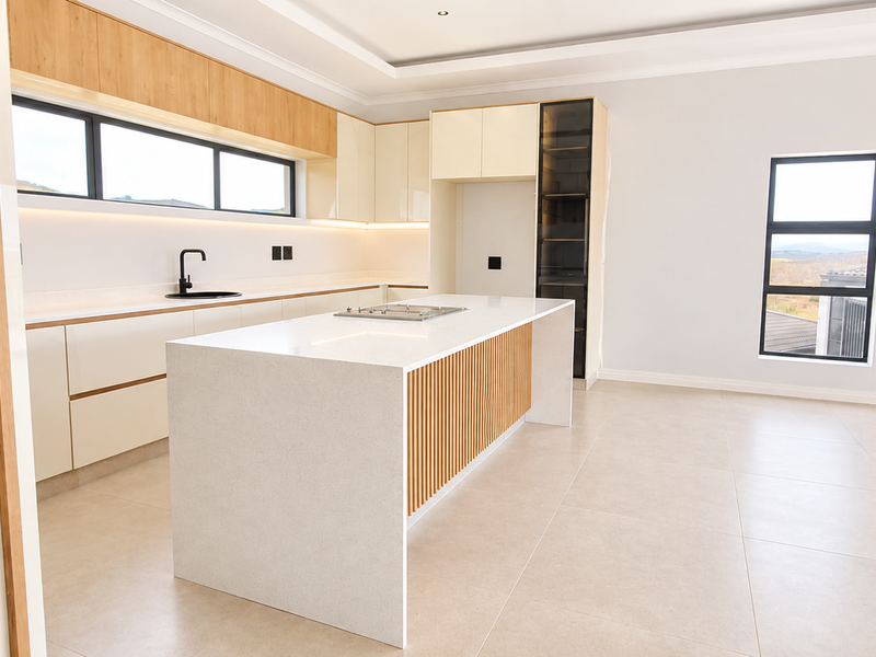 Modern, minimalist kitchen featuring a central island with stone countertops, sleek cabinetry, integrated gas cooktop, and high-quality finishes throughout.