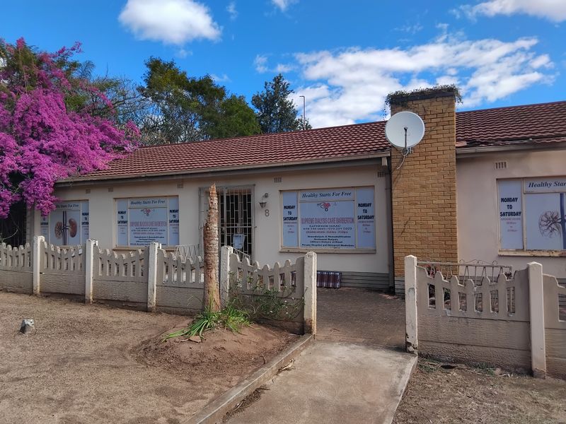 Front elevation of a single-story building featuring a tiled roof, brick chimney, and concrete boundary fencing, currently utilized for commercial medical services.