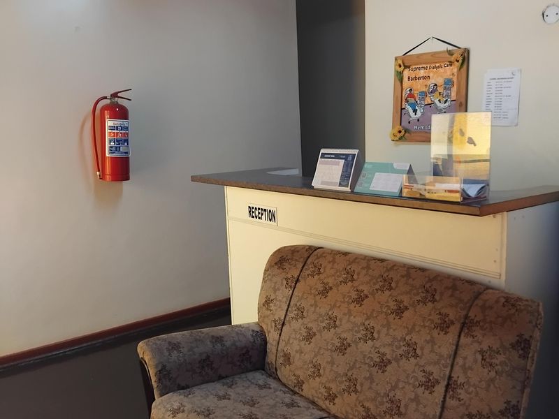 A commercial reception area featuring a built-in counter, timber ceiling, and wall-mounted fire safety equipment.