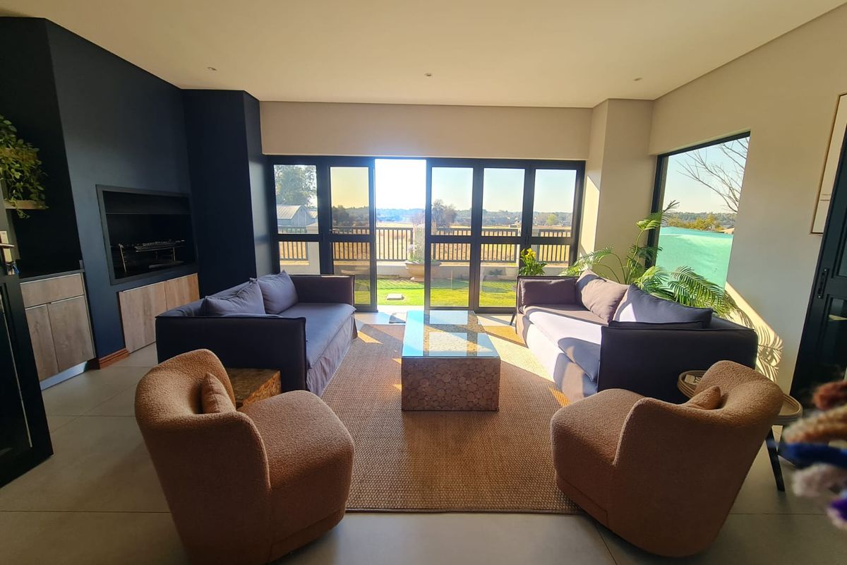 Modern living room featuring a built-in fireplace, large sliding glass doors providing natural light, and seamless access to the outdoor patio area.