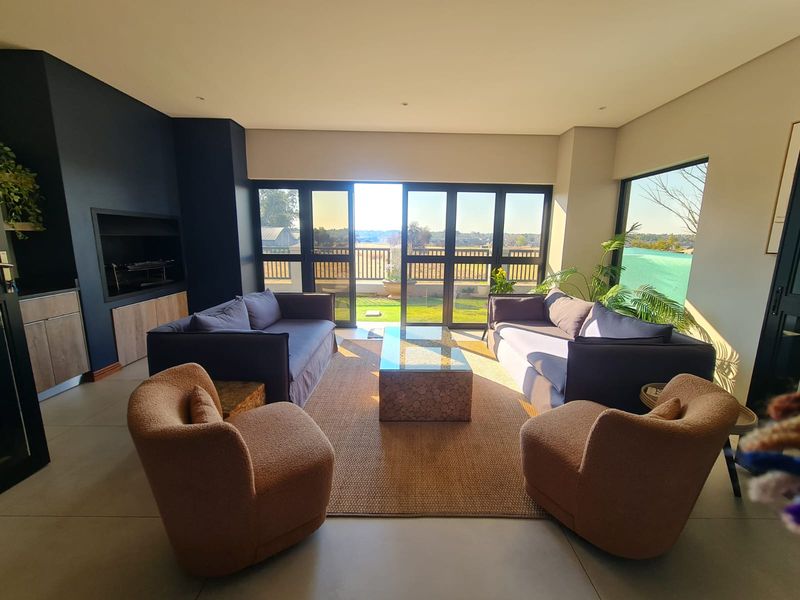 Modern living room featuring a built-in fireplace, large sliding glass doors providing natural light, and seamless access to the outdoor patio area.