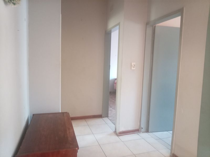 A functional hallway area with tiled flooring and access to adjacent rooms, featuring neutral wall finishes and standard internal door frames.
