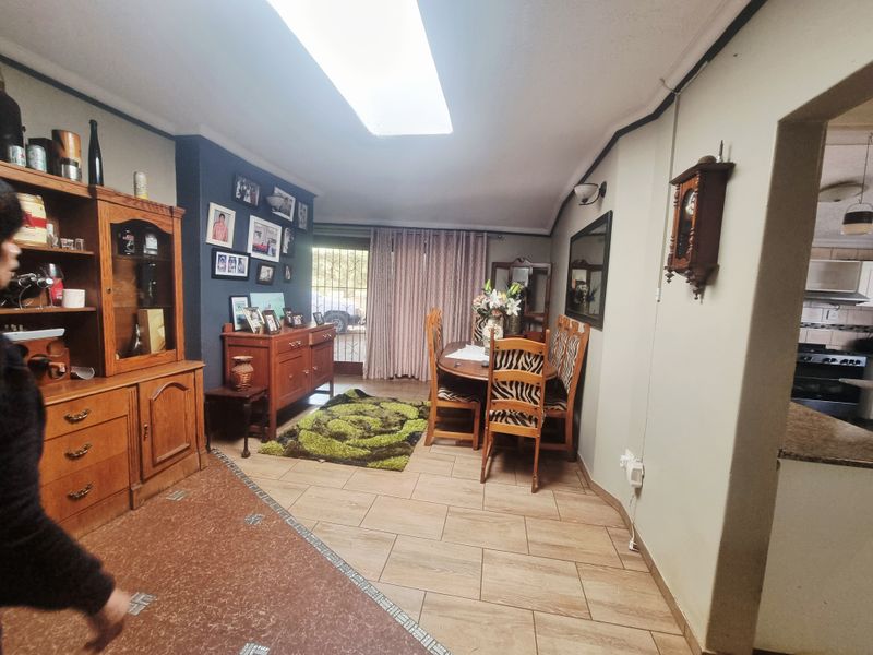 Dining room featuring tiled flooring, a central skylight, and direct access to the exterior via a sliding glass door.