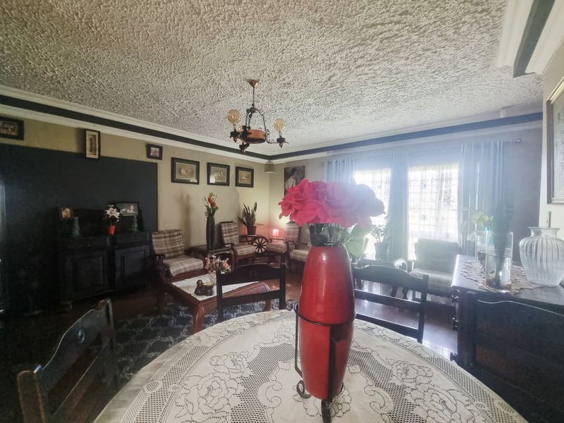 A living room featuring a textured popcorn ceiling, crown molding, and a sliding glass door providing natural light.