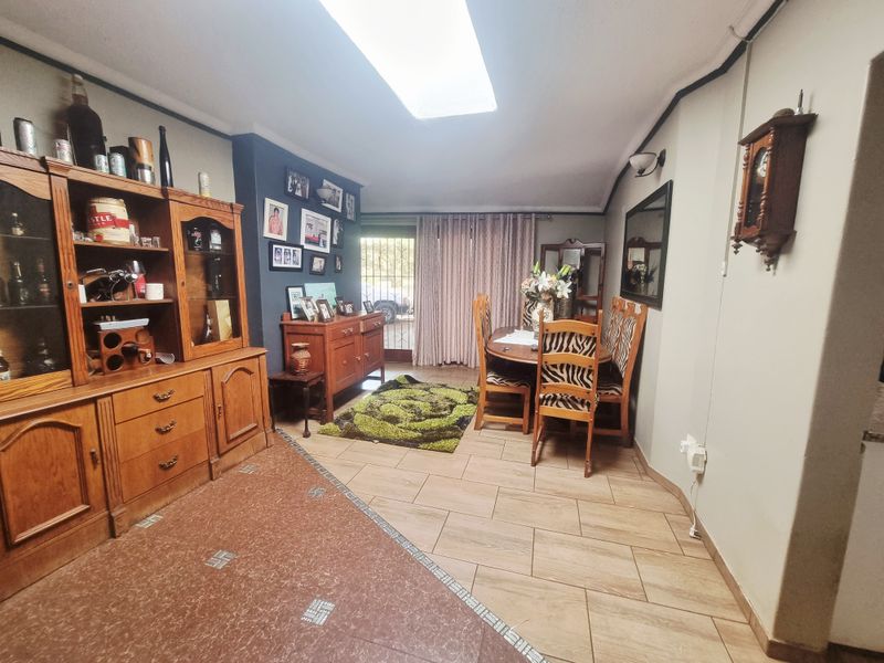 A dining room featuring tiled flooring, a skylight for natural illumination, and a sliding glass door providing access to the exterior.