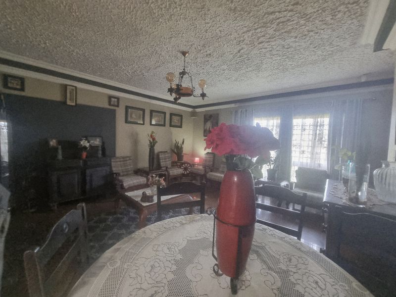 A living room featuring a textured ceiling, crown molding, and sliding glass doors providing natural light.