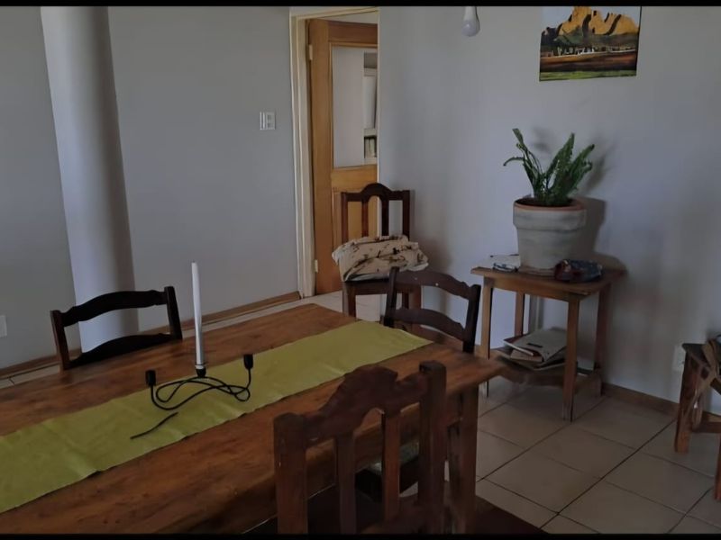 A dining area featuring neutral walls and tiled flooring, providing a functional space for meals.