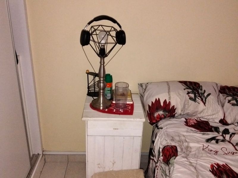 A bedroom featuring tiled flooring and a built-in cupboard, providing a functional living space.