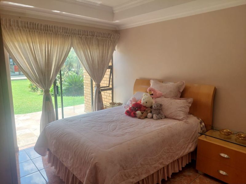 A bedroom featuring tiled flooring and a sliding glass door providing direct access to the garden area.