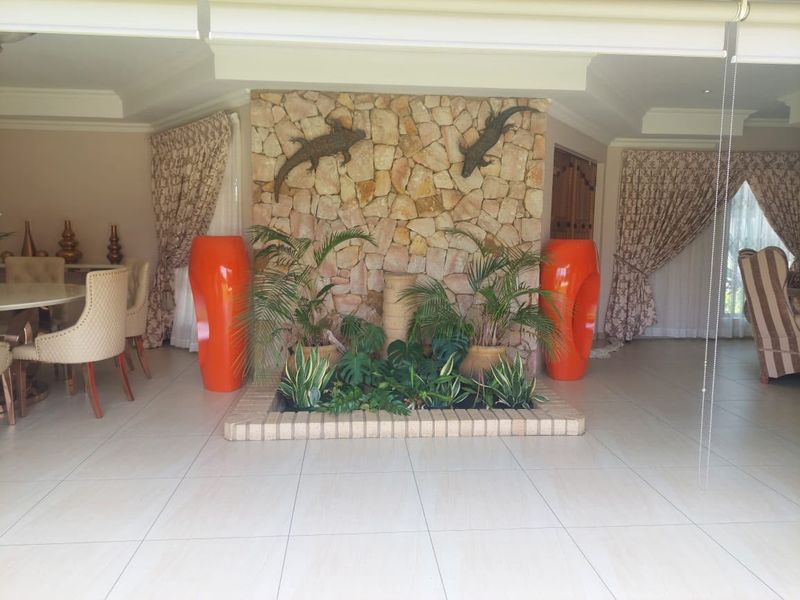 Spacious living area featuring a prominent stone feature wall with an integrated indoor planter bed and neutral tiled flooring.