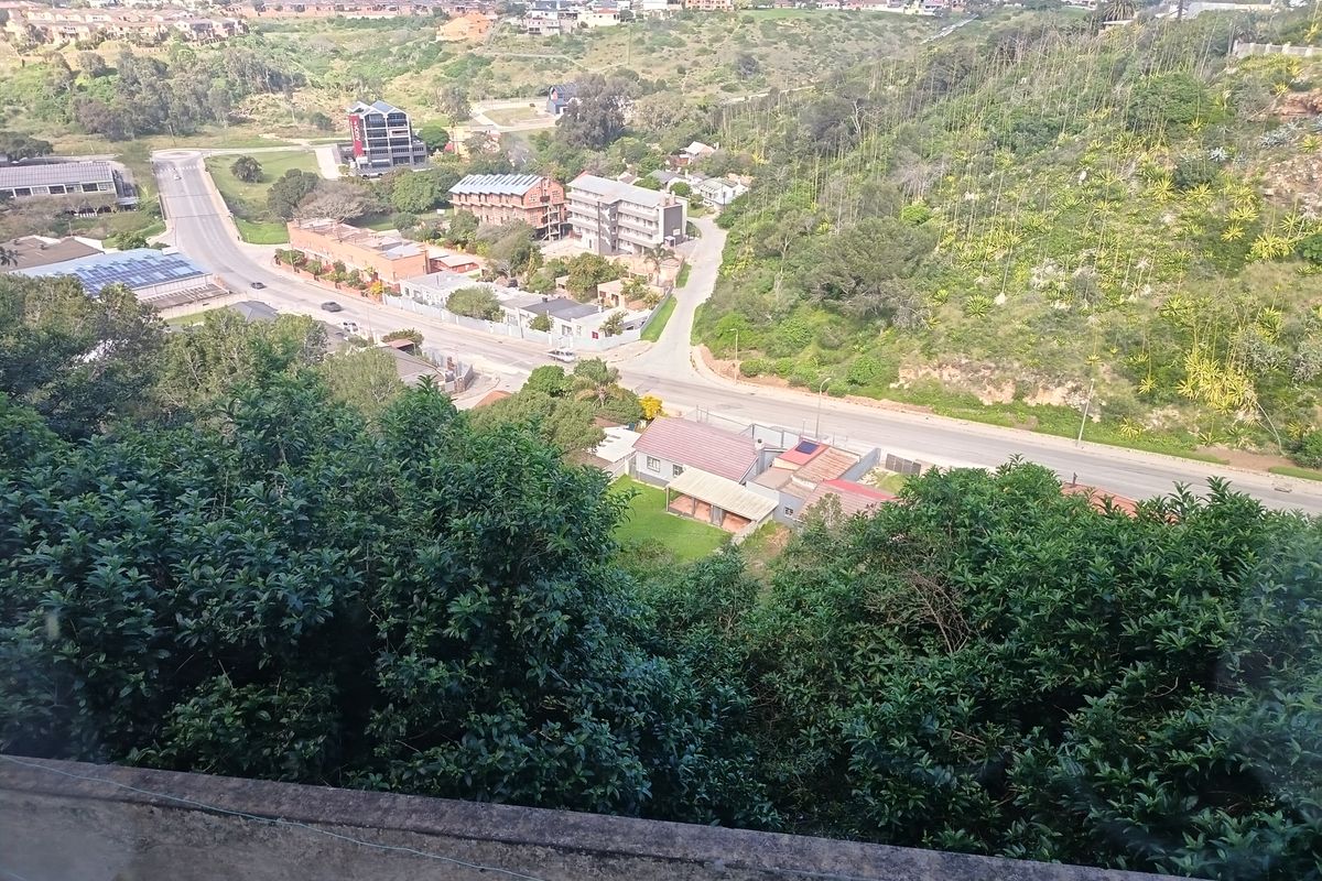 Elevated panoramic view overlooking the surrounding neighborhood, local roads, and lush green hillside landscape.
