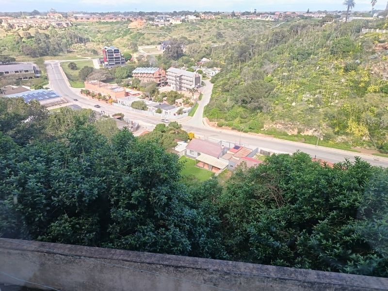 Elevated panoramic view overlooking the surrounding neighborhood, local roads, and lush green hillside landscape.