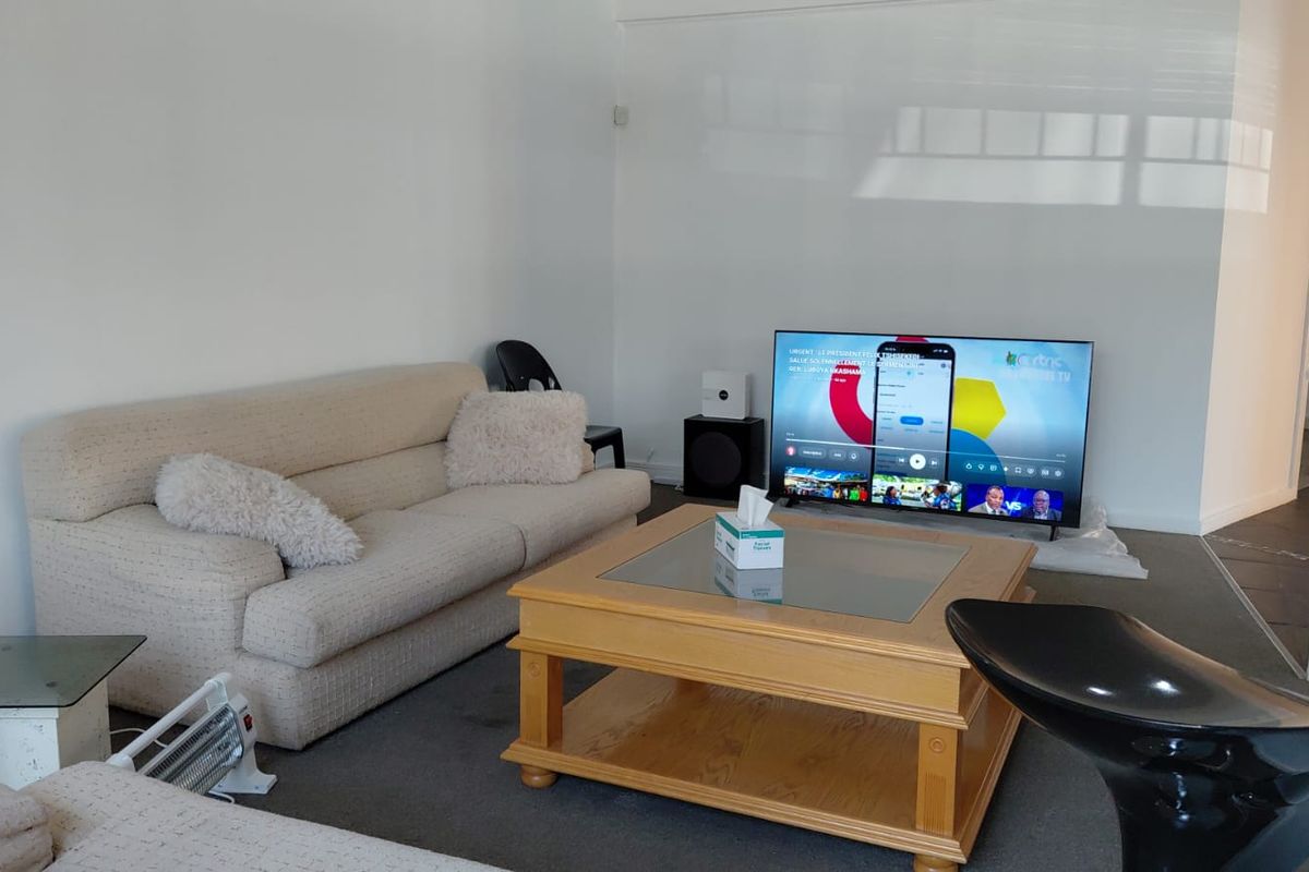 A living room space with neutral walls and carpeted flooring, offering a blank canvas for interior design updates.