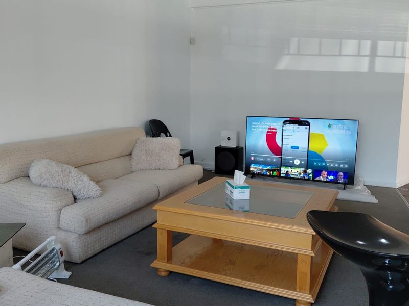 A living room space with neutral walls and carpeted flooring, offering a blank canvas for interior design updates.