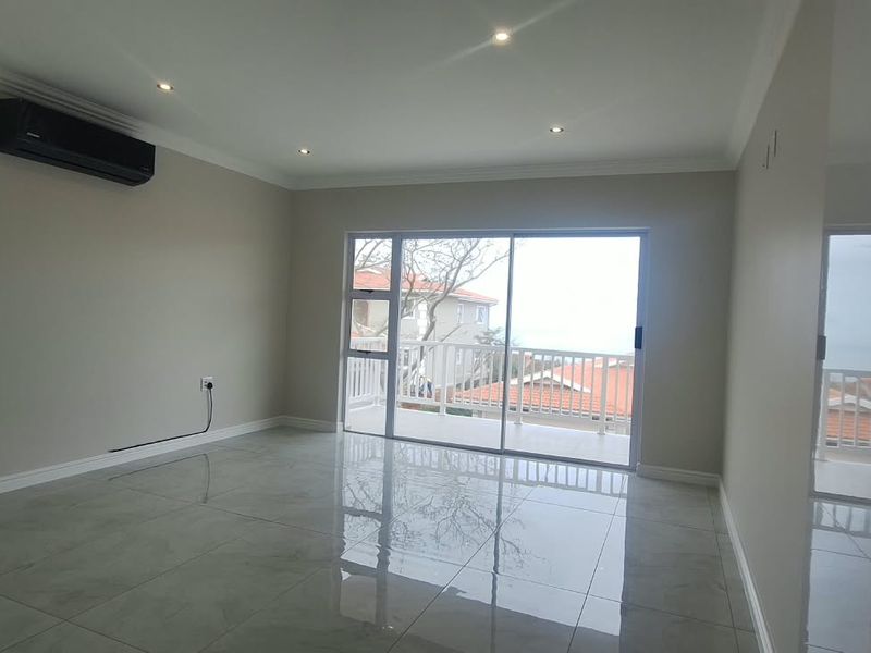 Spacious bedroom featuring polished tiled floors, recessed lighting, a split-system air conditioner, and sliding glass doors leading to a private balcony.