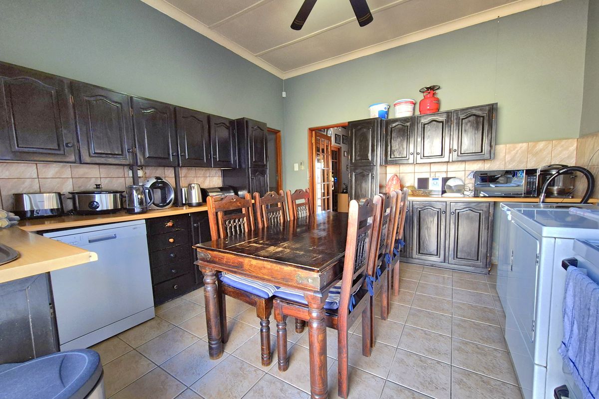 A functional kitchen featuring dark wood cabinetry, tiled flooring, and a tiled backsplash, providing a practical space for cooking and dining.