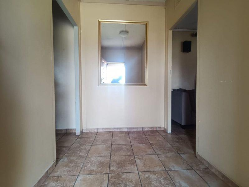 A functional hallway featuring tiled flooring and neutral wall tones, providing access to adjacent rooms within the home.