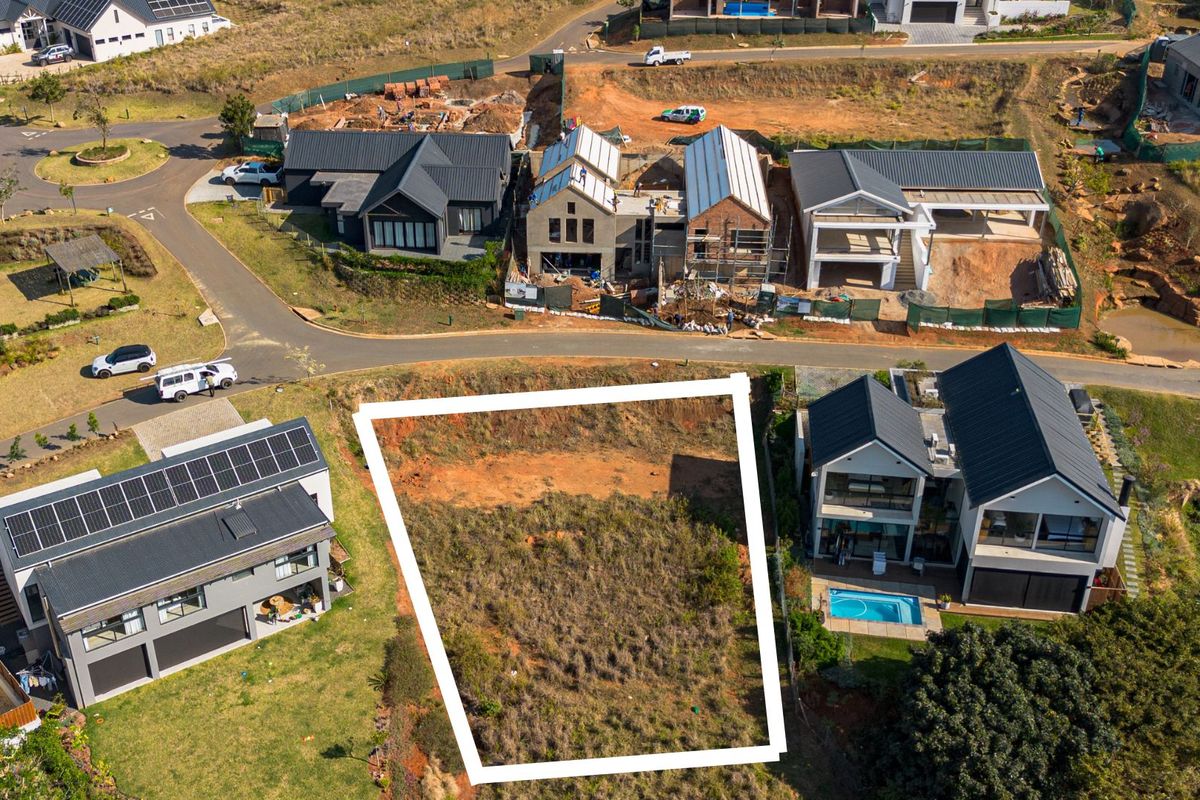 An aerial view of a vacant residential plot situated within a developed estate, highlighting the available land for future construction.