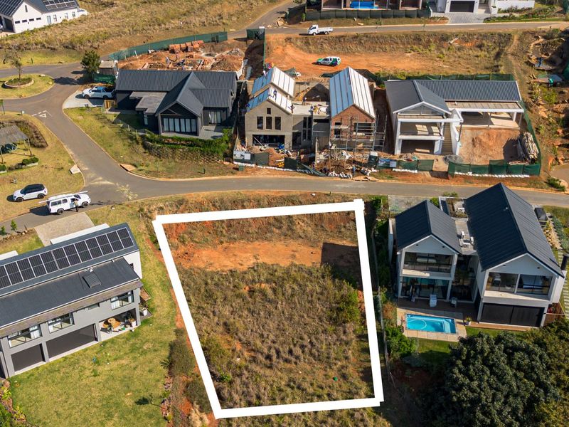 An aerial view of a vacant residential plot situated within a developed estate, highlighting the available land for future construction.