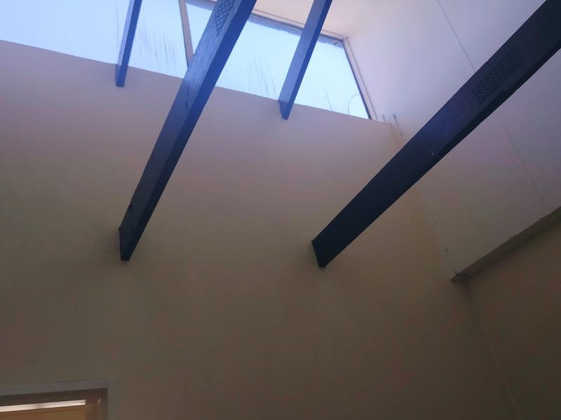 A high-ceilinged interior space featuring exposed timber beams and a large skylight, providing ample natural light.
