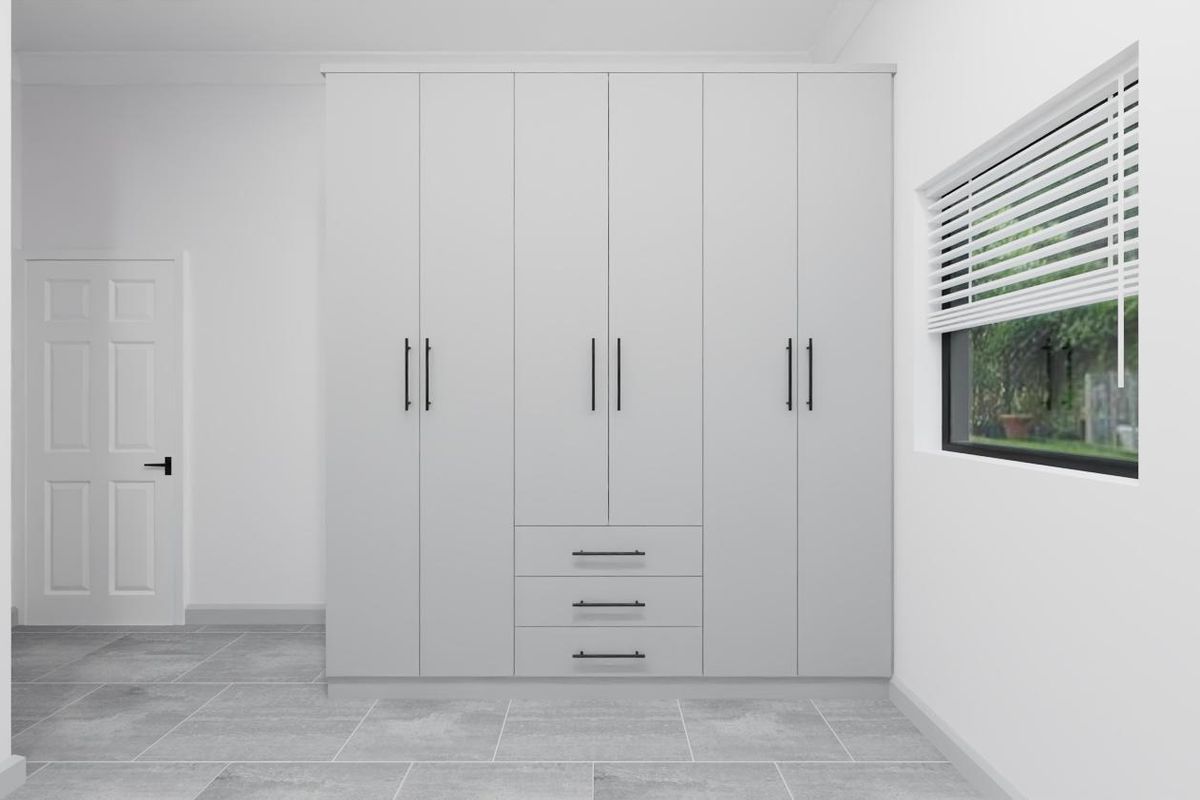 A clean, modern bedroom featuring large built-in wardrobes with matte hardware, neutral tiled flooring, and a window fitted with venetian blinds.