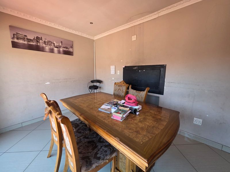 Dining room featuring tiled flooring and coved ceiling detailing, currently requiring cosmetic wall repairs and fresh paint to improve the overall aesthetic.