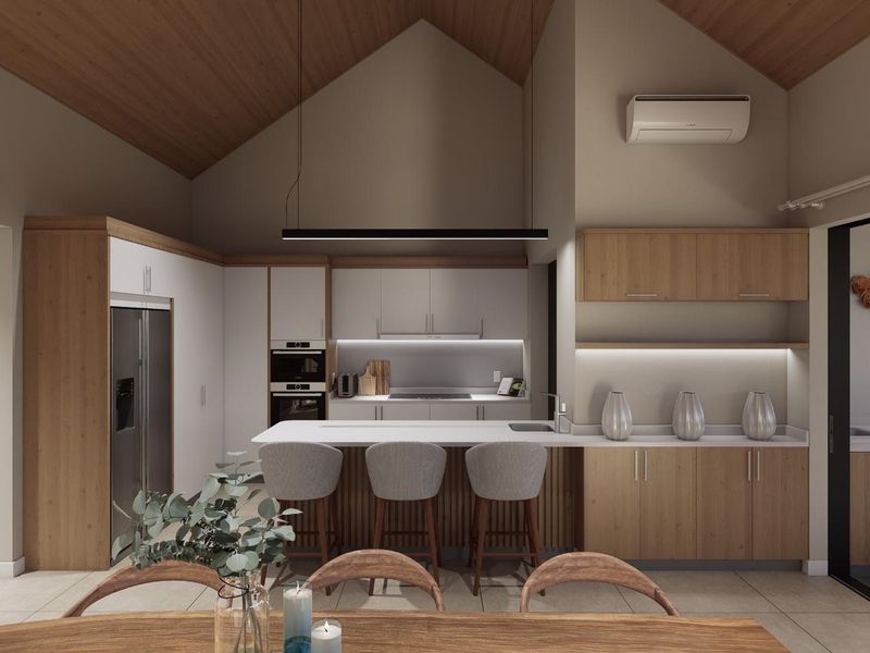 Modern open-plan kitchen featuring a vaulted timber ceiling, integrated appliances, a central island with breakfast bar seating, and sleek cabinetry with under-cabinet lighting.