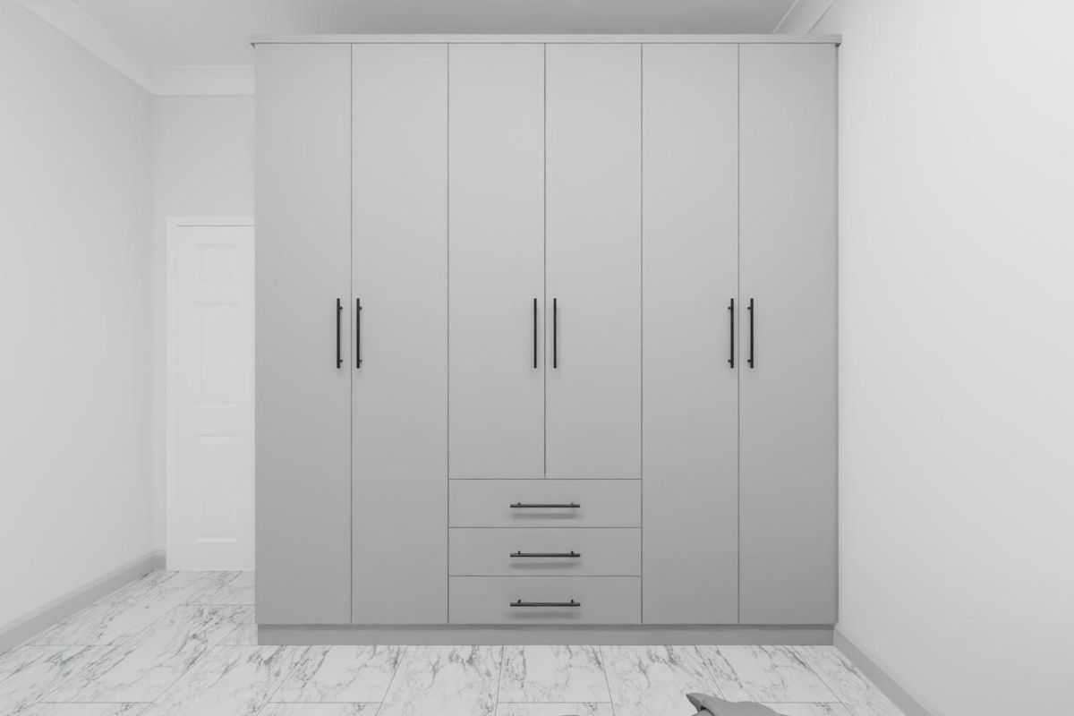 A clean, modern bedroom featuring a large, floor-to-ceiling built-in wardrobe with matte grey cabinetry and marble-look tiled flooring.