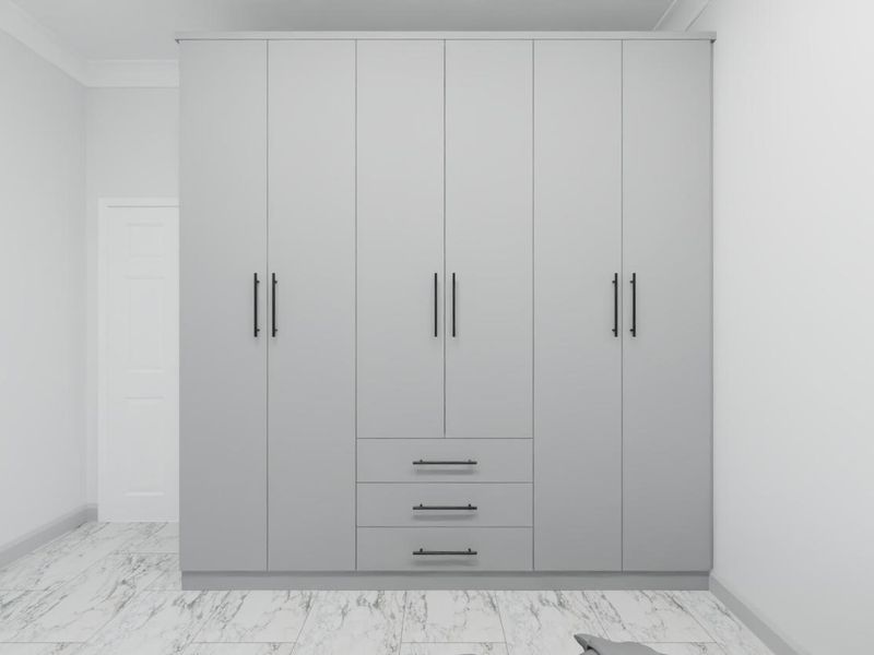 A clean, modern bedroom featuring a large, floor-to-ceiling built-in wardrobe with matte grey cabinetry and marble-look tiled flooring.