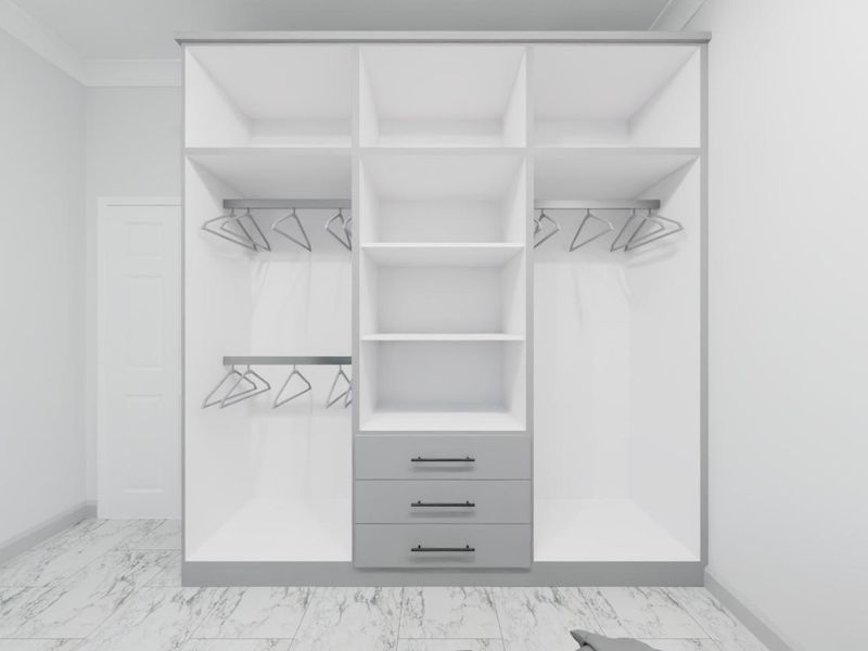 A modern bedroom featuring a large, custom-built wardrobe with integrated shelving, hanging rails, and drawers, complemented by sleek marble-look floor tiles.