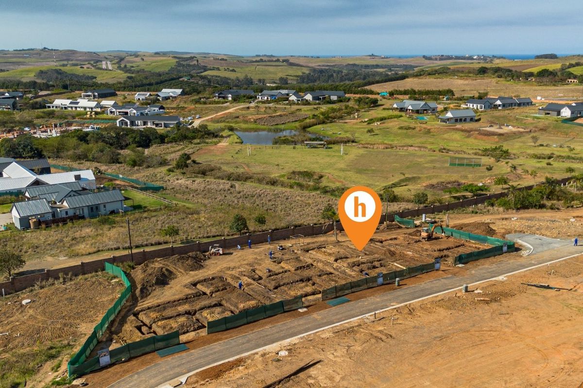 Aerial view of a residential construction site showing excavated foundations and perimeter fencing within a developing estate.