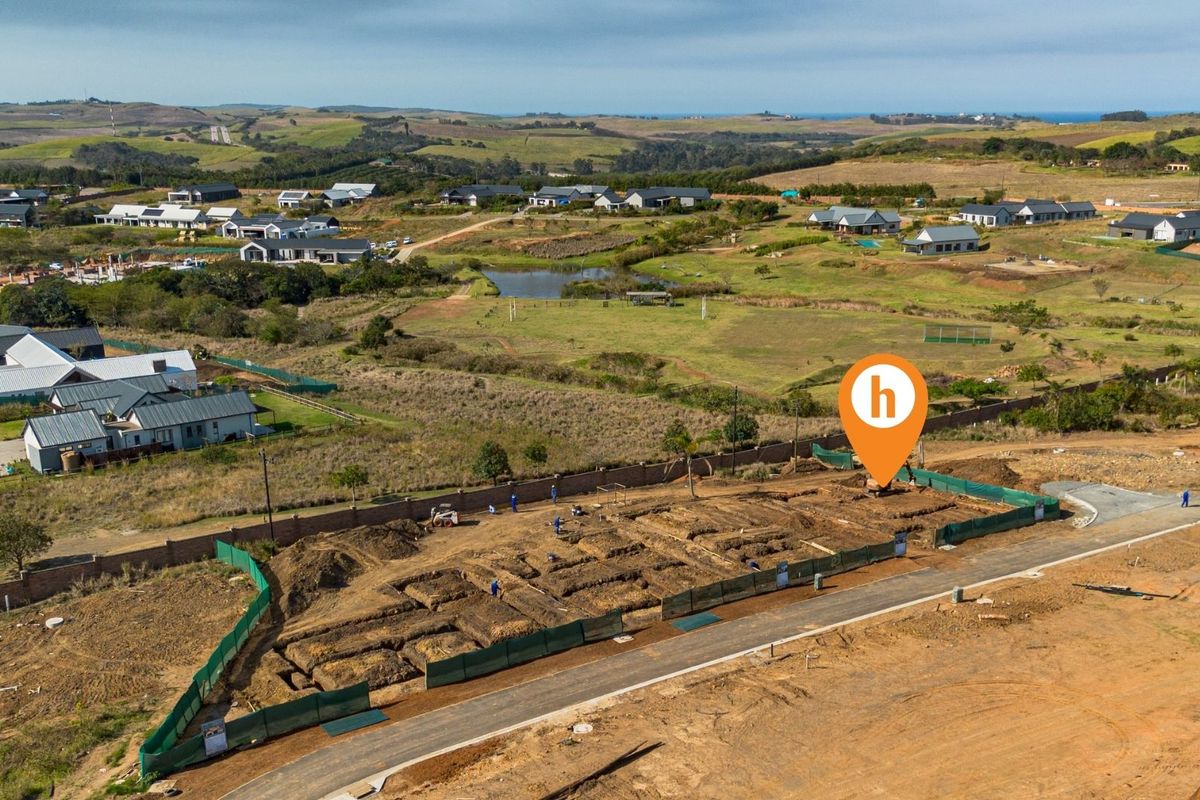 Aerial view of a residential construction site showing excavated foundations and perimeter walling within a developing estate.