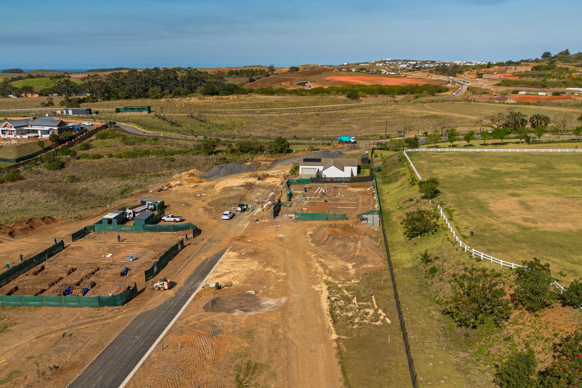 Aerial view of a residential development site showing ongoing construction, foundation work, and surrounding landscape in a rural estate setting.