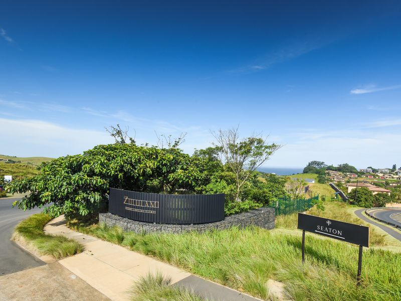Entrance signage for Zululami Coastal Estate featuring a modern gabion wall and landscaped surroundings with views of the coastal landscape.