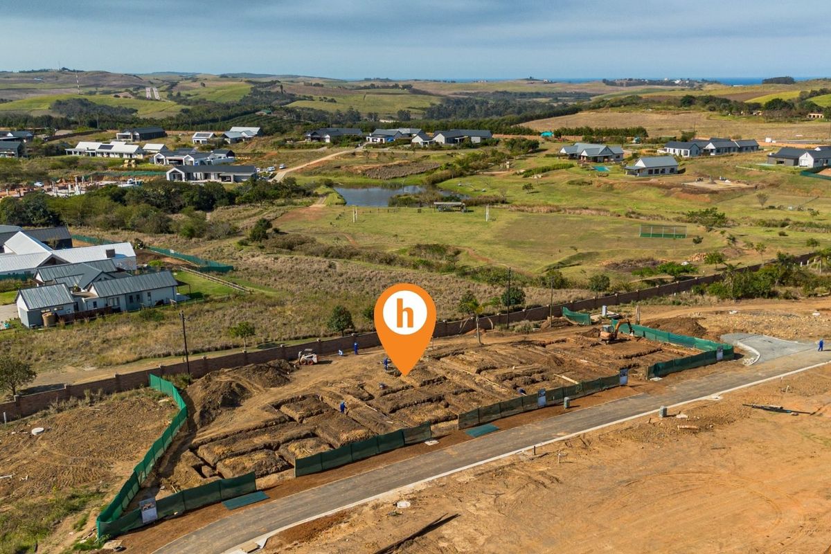 Aerial view of a residential construction site showing excavated foundation trenches and perimeter walling within a developing estate.