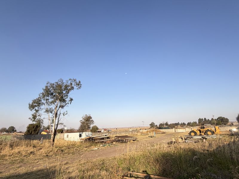 Expansive undeveloped small holding land featuring perimeter precast concrete walling and natural vegetation, offering significant potential for future development or landscaping.