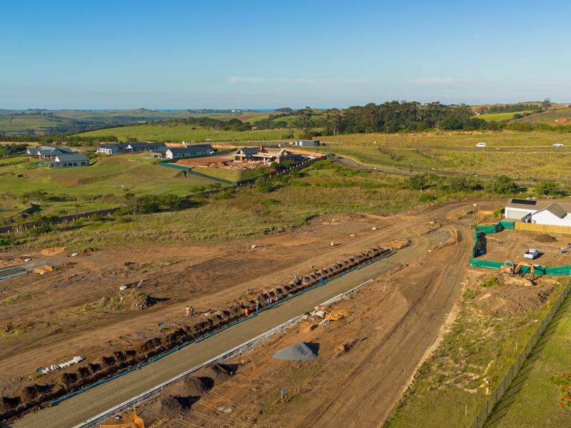 Aerial view of a residential development site showing ongoing road infrastructure construction, utility trenching, and surrounding estate landscape.