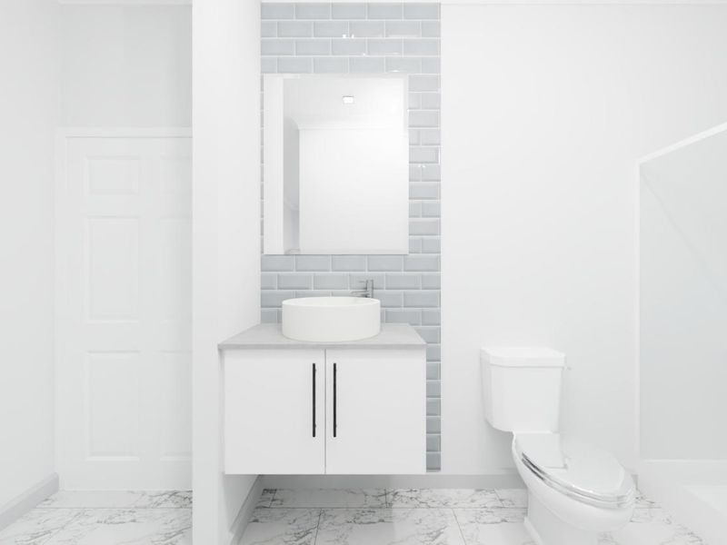 A modern, clean bathroom featuring a wall-mounted vanity with a vessel sink, subway tile backsplash, and marble-look flooring.